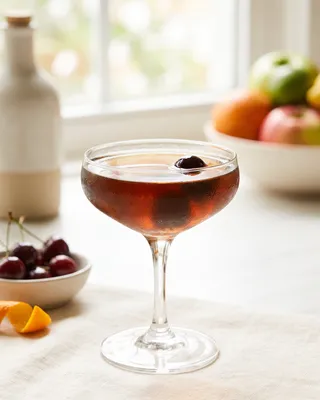 Black Manhattan i coupe med cocktailkirsebær
