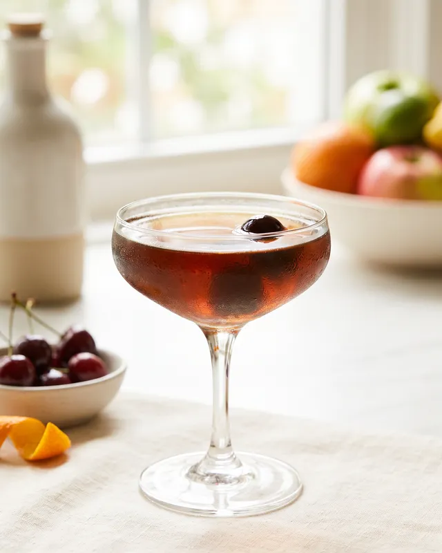 Black Manhattan i coupe med cocktailkirsebær