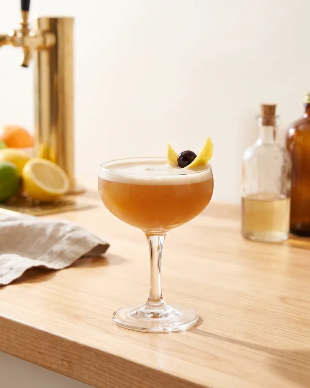 Boston Sour i coupe med citron og cocktailkirsebær