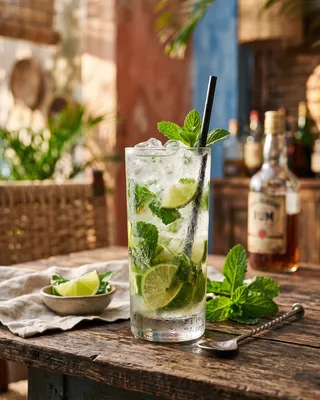 Mojito cocktail med lime, rom og mynte serveret i et højt glas.