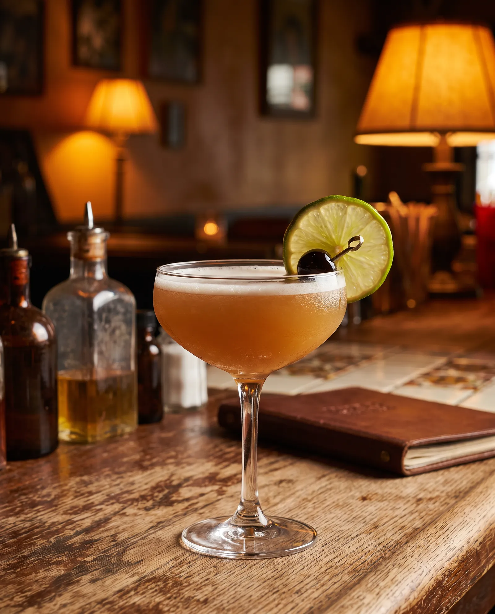 Tequila Sour i coupe med lime og cocktailkirsebær
